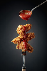 Wall Mural - Fried chicken with ketchup on a fork.