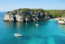 Beautiful Beach With Sailing Boat Yacht, Menorca Island, Spain. Sailing Boats In A Bay. Summer Fun, Enjoying Life, Yachting, Travel And Active Lifestyle Concept