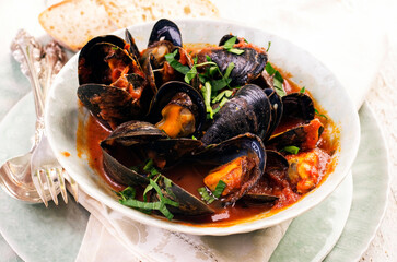 traditional italian mussels und red wine tomato sauce with blue mussels served as close-up in a desi