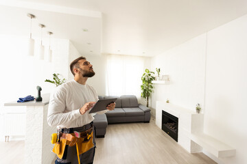 Wall Mural - Smiling young caucasian male worker with tablet during work in kitchen