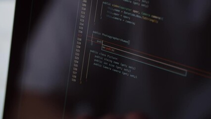 A web application developer writes the code. Cropped view of an experienced programmer working at a computer.