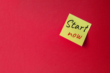 Wall Mural - Start now symbol. Orange steaky note with words Start now. Beautiful red background. Business and Start now concept. Copy space.