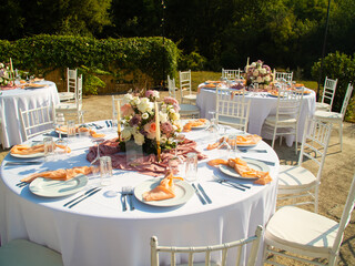 Wall Mural - Wedding banquet concept. Chairs and round table for guests, served with cutler and, flowers and crockery and covered with a tablecloth