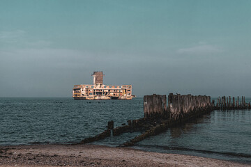 Wall Mural - Old ruined wooden pier and a sandy beach