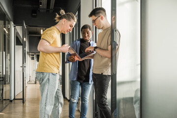 A young developer gives new project tasks to his partners. Business people are discussing a new business project in the office. Coding technologies, site design. Successful diverse Teamwork