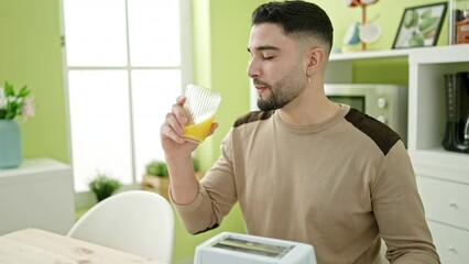 Wall Mural - Young arab man having breakfast sitting on table at home