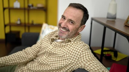 Sticker - Middle age man smiling confident sitting on sofa at home