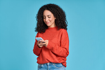 young adult smiling happy pretty latin woman holding mobile phone looking at smartphone, typing mess
