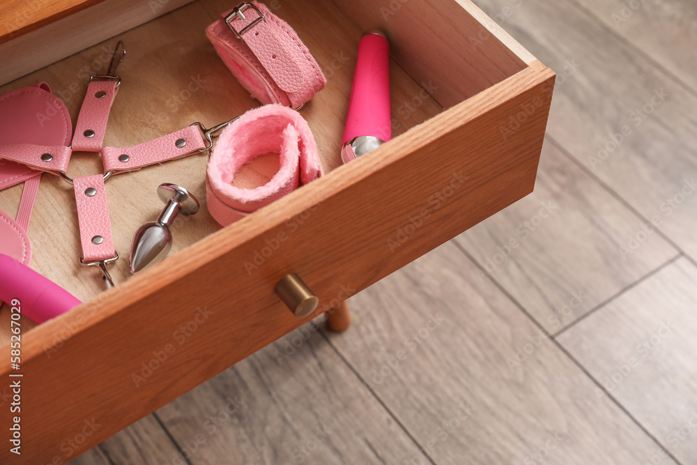 Foto de Stock Open drawer with sex toys in bedroom, closeup | Adobe Stock