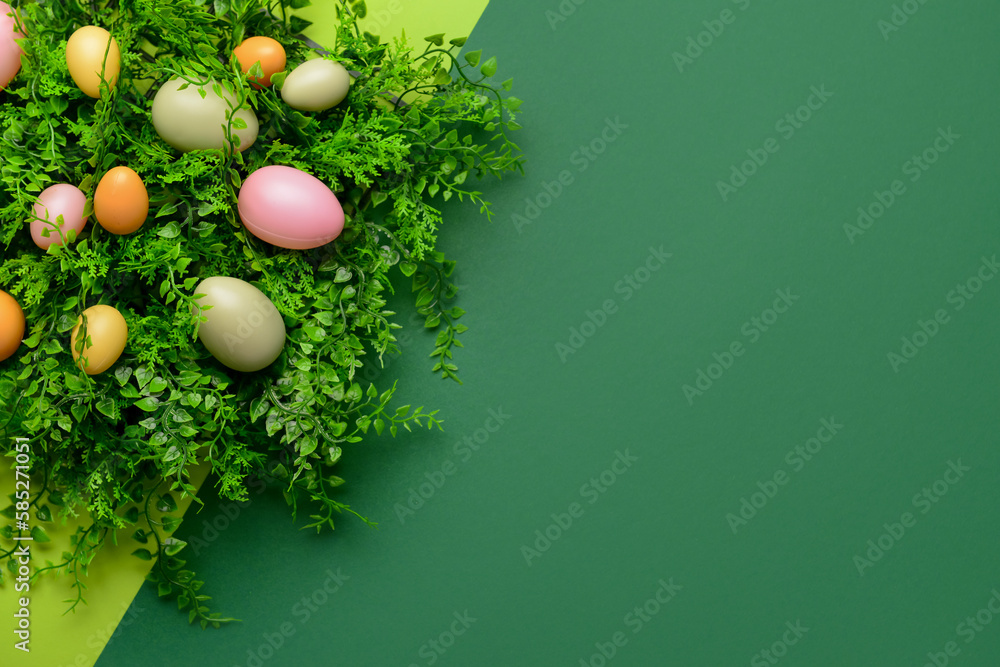 Easter eggs and plant leaves on green background