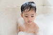 © torwaiphoto - boy taking a bath in the tub take bath he plays with bubbles