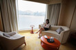 © LT - woman take a break and reading at home with Victoria harbour city view in Hong Kong