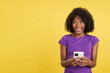 © Iván Moreno - Happy woman with afro hair looking up while using mobile