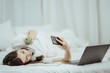© Kritdanai - beautiful girl talking on the phone in bed Beautiful young woman doing herself on bed at home