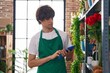 Young blond man florist using touchpad at flower shop