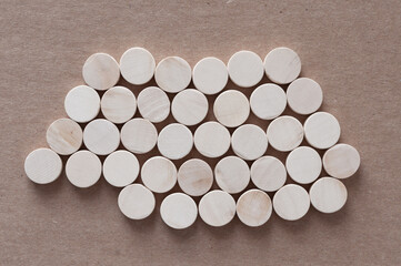 Sticker - isolated bed of round wooden shapes on cardboard