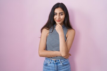 Wall Mural - Young teenager girl wearing casual striped t shirt looking confident at the camera smiling with crossed arms and hand raised on chin. thinking positive.