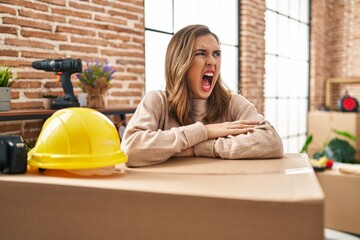 Canvas Print - Young woman moving to a new home angry and mad screaming frustrated and furious, shouting with anger. rage and aggressive concept.