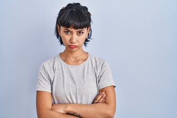 Canvas Print - Young hispanic woman wearing casual t shirt over blue background skeptic and nervous, frowning upset because of problem. negative person.