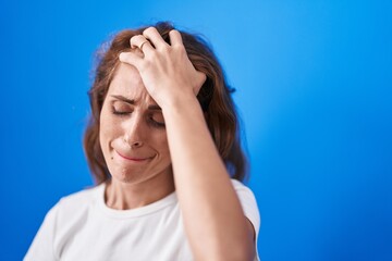 Wall Mural - Young beautiful hispanic woman suffering for headache crying over isolated blue background