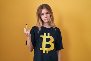 Sticker - Blonde caucasian woman wearing bitcoin t shirt showing middle finger, impolite and rude fuck off expression