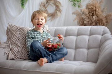 Canvas Print - Cute preschool child, boy, eating strawberries at home