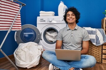 Sticker - Young hispanic man using laptop waiting for washing machine at laundry room