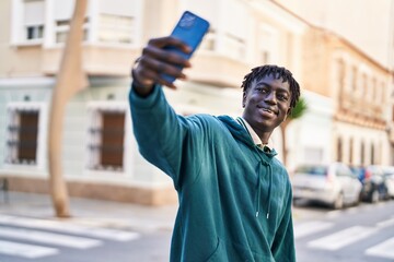 Wall Mural - African american man smiling confident making selfie by the smartphone at street