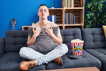 Canvas Print - Young man eating popcorn looking at the camera blowing a kiss being lovely and sexy. love expression.