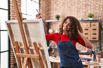 Sticker - Young hispanic woman artist listening to music drawing at art studio