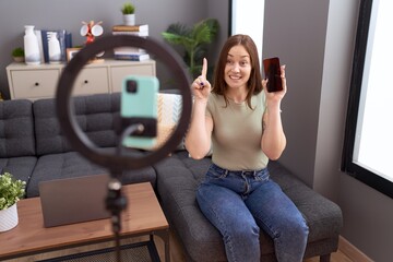 Poster - Beautiful brunette woman recording vlog tutorial with smartphone at home smiling with an idea or question pointing finger with happy face, number one