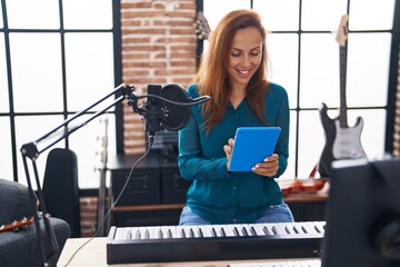 Wall Mural - Young woman artist using touchpad at music studio