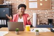 © Krakenimages.com - Young african american woman working at the office wearing glasses shouting and screaming loud to side with hand on mouth. communication concept.