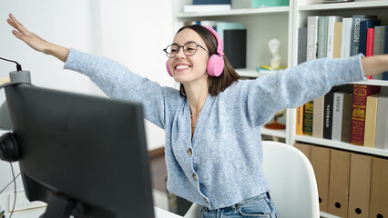 Canvas Print - Young beautiful hispanic woman student listening to music dancing at library university