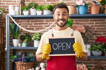 Sticker - Handsome hispanic man working at florist holding open sign smiling with a happy and cool smile on face. showing teeth.