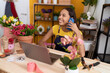 © Krakenimages.com - Young african american woman florist talking on smartphone using laptop at flower shop