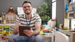 © Krakenimages.com - Young caucasian man working as teacher with tablet at kindergarten