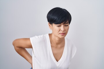 Sticker - Young asian woman with short hair standing over isolated background suffering of backache, touching back with hand, muscular pain