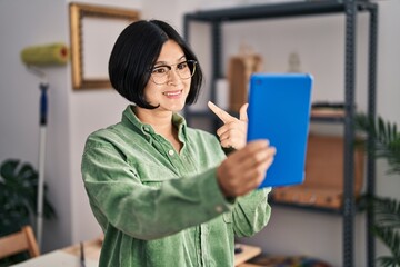 Poster - Young asian woman doing video call with tablet smiling happy pointing with hand and finger