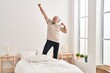 © Krakenimages.com - Middle age grey-haired man smiling confident dancing on bed at bedroom