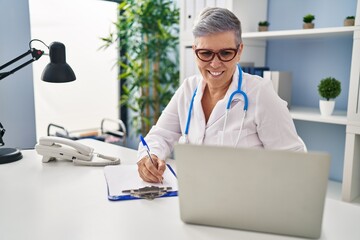 Sticker - Middle age woman wearing doctor uniform working at clinic