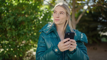 Poster - Young blonde woman using smartphone at park