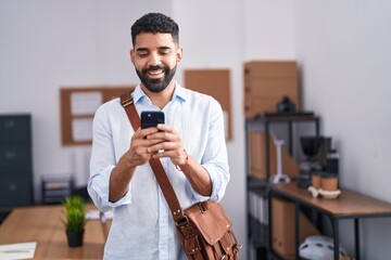 Sticker - Hispanic man with beard using smartphone at the office smiling with a happy and cool smile on face. showing teeth.