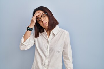 Wall Mural - Young hispanic woman standing over white background worried and stressed about a problem with hand on forehead, nervous and anxious for crisis