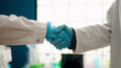 © Krakenimages.com - Man and woman wearing scientist uniform shake hands at laboratory