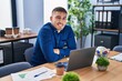 © Krakenimages.com - Young hispanic man business worker sitting with arms crossed gesture at office