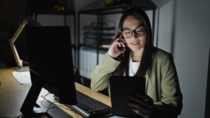 Sticker - Young beautiful hispanic woman business worker using tablet talking on smartphone at office