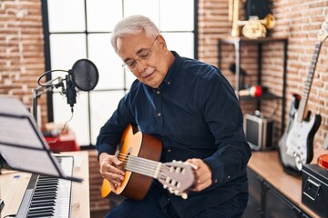 Wall Mural - Senior man musician playing guitar at music studio