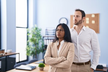 Man and woman business workers standing with arms crossed gesture at office