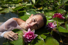 An Attractive Woman In The Lake Surrounded By Water Lilies